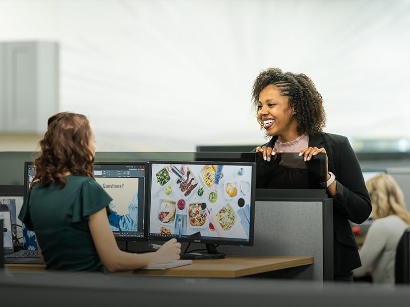 Two employees chat happily in front office area